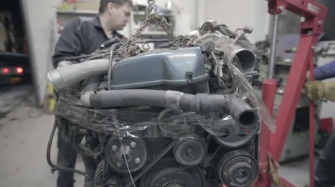 Experienced workers move the car engine Stock Footage