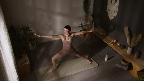 Experienced Yoga Devotee Performing Warrior Asana Flow at Home Stockbeeldmateriaal 329741068