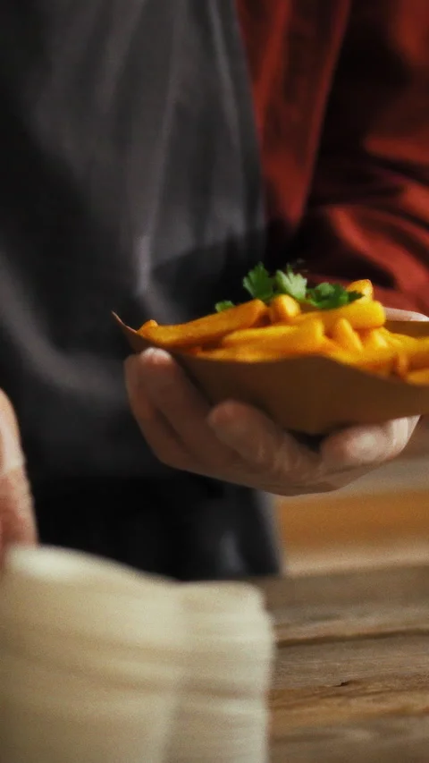 Experienced young chef adds fresh herbs to fries at fast food restaurant Stock Footage 331573993