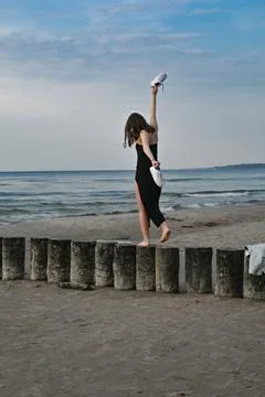 Experiencing the Delight of Balancing on the Beach A Joyful Moment by the Serene Stock Photos