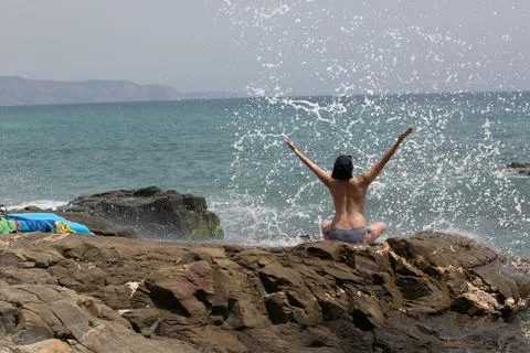 Experiencing a Joyful Moment at the Beach with the Refreshing Splashing Wav.. Stock Photos
