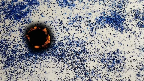 Experiment showing fire spreading over a surface with blue particles 動画素材 342831813