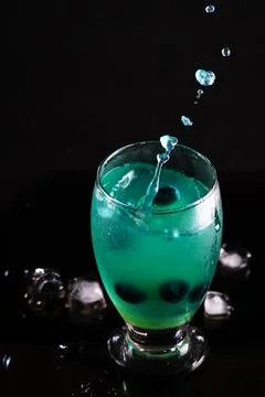 Experimental glowing cocktail with splash effect and dark luxury aesthetic Stock Photos