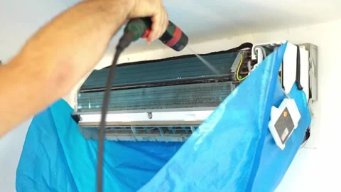 Expert air conditioner cleaning process in a residential home during summer heat Stock Footage 304035920