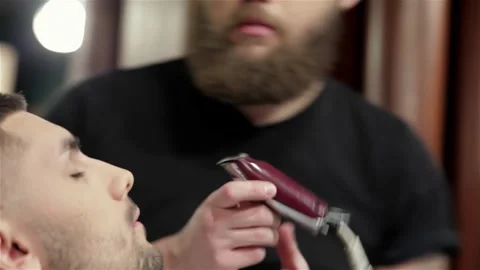 Expert barber skillfully shaping a beard at a trendy hair salon Video stock 311818975