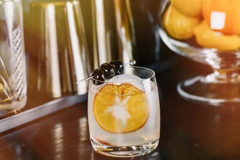 Expert Bartender is making cocktail at bar. Stock Photos