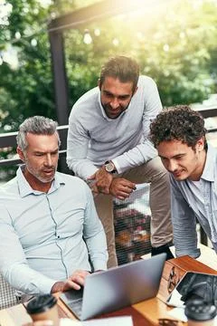 Expert business knowledge times three. a team of colleagues using a laptop Stock Photos