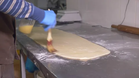 The expert chef greases the dough prepared for baking with butter Stock Footage 170735758