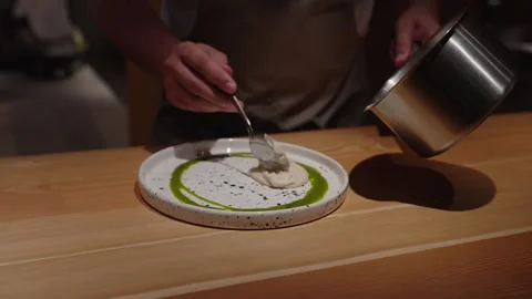 Expert chef serving plate with creamy puree garnish and green sauce. Stock Footage 314117045