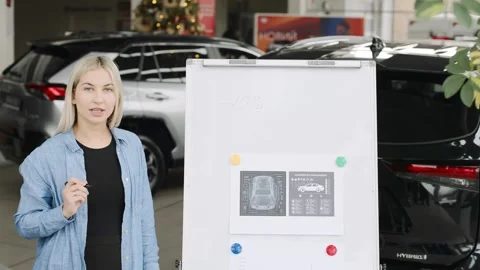 Expert demonstrates vehicle features in a car showroom with slow motion Stock-Footage 312665755