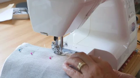 Expert female hands using sewing machine stitching fabic togeather to make arts Stock Footage 77017595