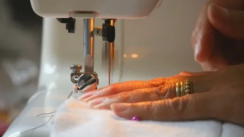 Expert female hands using sewing machine stitching fabic togeather to make arts Stock Footage 77114257