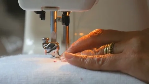 Expert female hands using sewing machine stitching fabic togeather to make arts Stock Footage 77114390