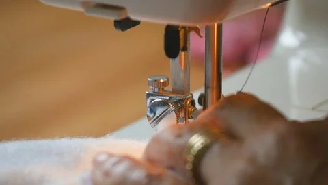 Expert female hands using sewing machine stitching fabic togeather to make arts Stock Footage 77114945