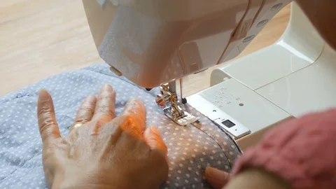 Expert female hands using sewing machine stitching fabic togeather to make arts Stock Footage 77115975