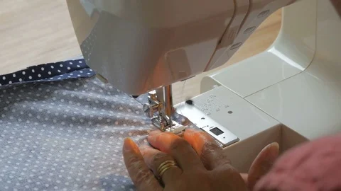 Expert female hands using sewing machine stitching fabic togeather to make arts Stock Footage 77116758