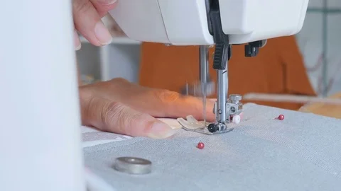 Expert female hands using sewing machine stitching fabic togeather to make arts Stock Footage 77132631