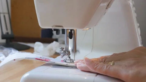 Expert female hands using sewing machine stitching fabic togeather to make arts Stock Footage 77174756