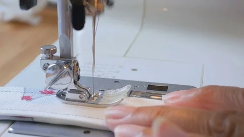 Expert female hands using sewing machine stitching fabic Stock-Footage 77864116
