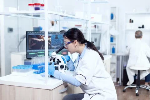 Expert in genetics doing research using microscope to analise chemical Stock Photos