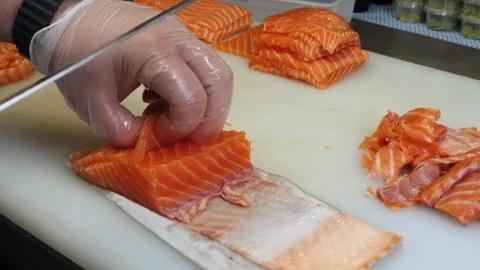 With expert hands, the chef slices fresh salmon into even pieces The sharp knife Vidéo 284968019
