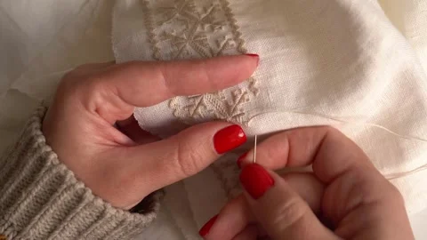 Expert hands create delicate embroidery on a cream fabric Video stock 310171798
