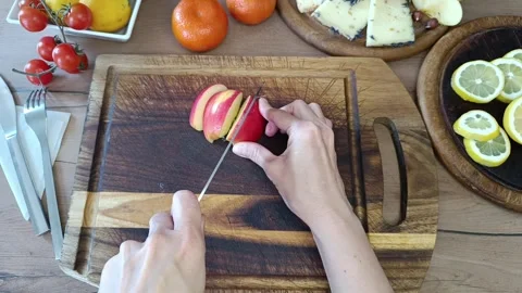 Expert hands skillfully slice fresh apples while surrounded by vibrant fruits Stock Footage 307852125