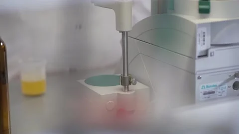 Expert immerses the testing apparatus into a measuring cup close up Video stock 130356723