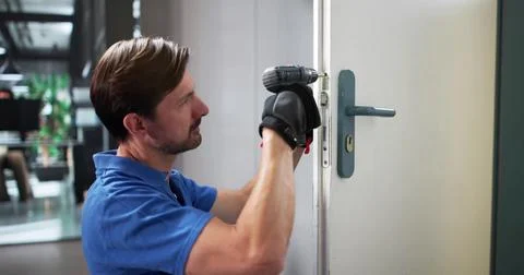 Expert Locksmith Skillfully Installs And Repairs Doors For Busy Clients Stock Photos