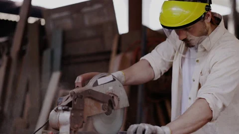 Expert male carpenter active is using electric machine sawing wood Stock Footage 161163243
