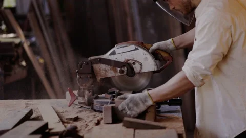 Expert male carpenter active is using electric machine sawing wood Stock Footage 161163687