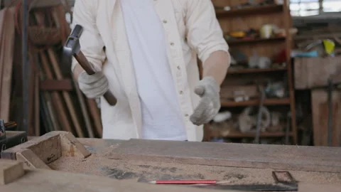 Expert male carpenter active is using electric machine sawing wood Stock Footage 249983119