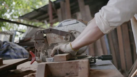 Expert male carpenter active is using electric machine sawing wood Stock Footage 249984048