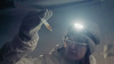 Expert observes thawing sample in cold environment. Technician meticulously Stock Footage 346474684