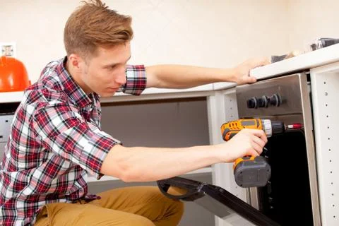 Expert panel fixing the kitchen oven Stock Photos