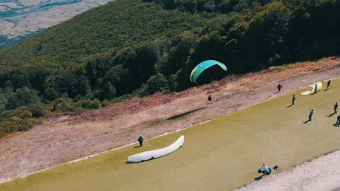 Expert paraglider flying off from a narrow start with his glider into a Video stock 266903920