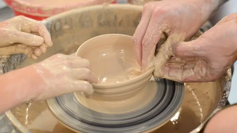 Expert potter teaches child to make ceramic bowl  on a potter wheel. Stock Footage 123854439