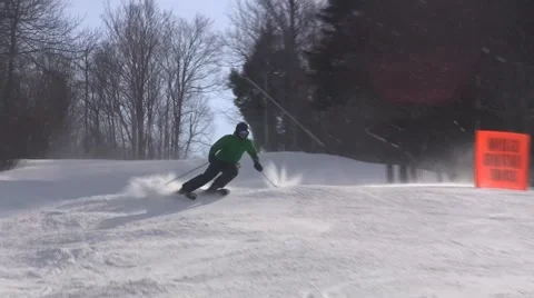 Expert skier doing aggressive turns in light snow with sun at back Video stock 41529982