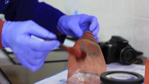 Expert smears the object of study with magnetic powder to identify traces Stock Footage 221428847