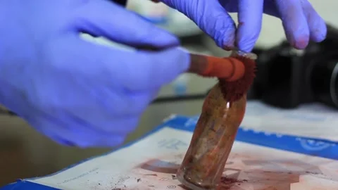 Expert smears the object of study with magnetic powder to identify traces Stock Footage 221428939
