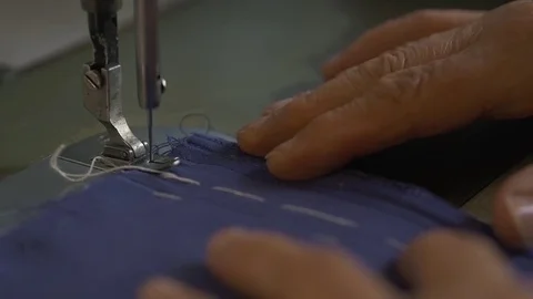 An expert tailor works on sew machine in slow motion Stock Footage 76131862