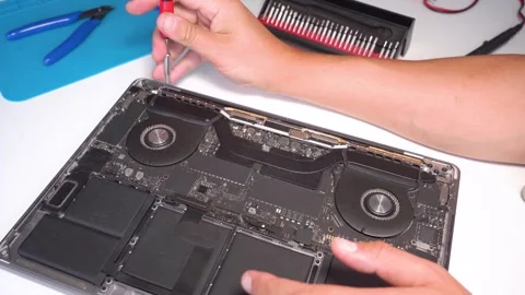 Expert technician repairs notebook computer in workshop with precision tools Stock Footage 309803670