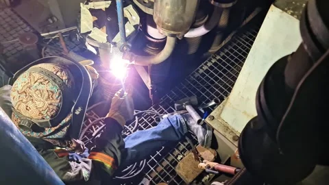 Expert welder performing precise TIG welding process on marine engine piping 스톡 동영상 347514026