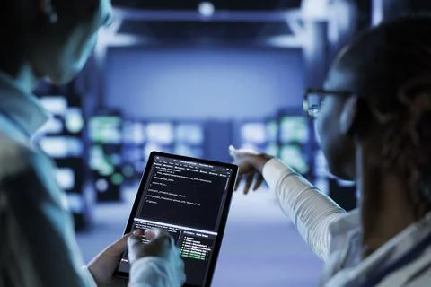 Experts code on tablet in data center Stockfoto's