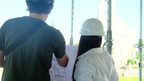 Experts discuss building layout holding sheet of paper Stock Footage 317606757