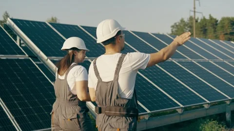 Experts study the operation of a solar power plant while walking around the farm Stock Footage 255981496