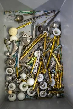 Explanted titanium plates, screws and hip prostheses lie in a gray plastic bo Stock Photos