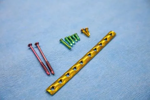 Explanted titanium surgical one-third tube plate and titanium screws of diffe Stock Photos