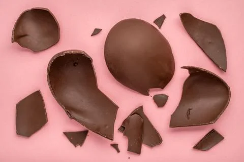 Exploded chocolate Easter egg over pink background, holiday concept Foto stock
