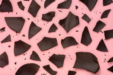 Exploded chocolate Easter egg over pink background, holiday concept Stock Photos